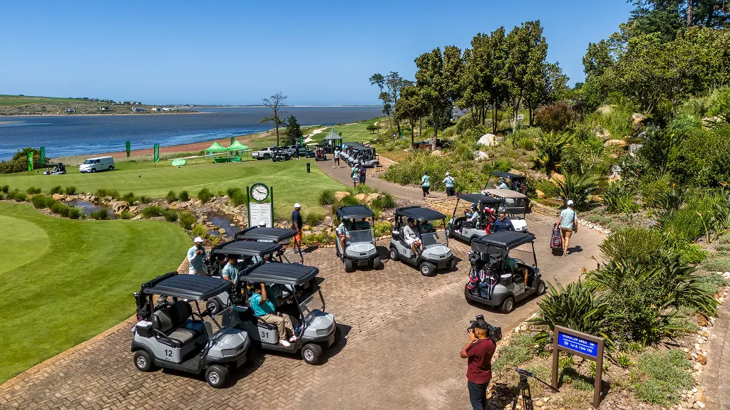 Golf day at the Arabella course, with delegates gathering at golf carts overlooking the Bot River Lagoon.