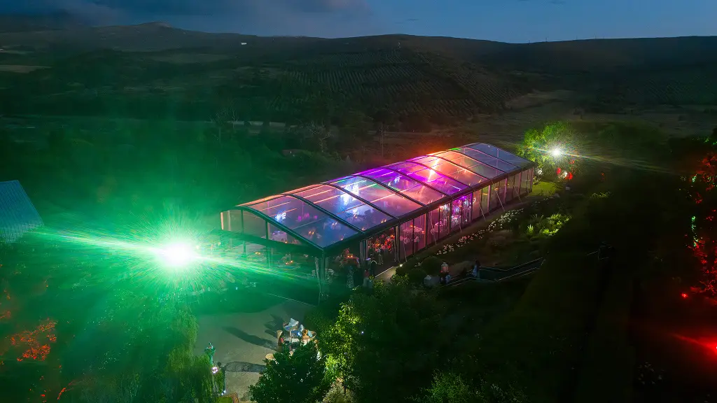 An aerial night view of the illuminated SATNAC 2025 gala marquee set against the surrounding hills.